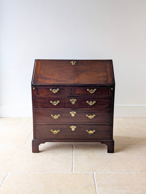 Antique George III solid mahogany bureau with a fall front, fitted interior and graduated drawers raised on bracket feet.