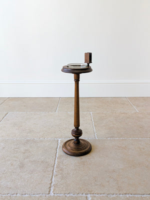 Antique Edwardian solid mahogany floor-standing smoker's stand featuring a dished gallery top with glass liner, matchbox sleeve, turned column, and stepped circular base.