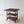 Load image into Gallery viewer, Antique early 20th century mahogany card table featuring a swivelling fold‑over green baize top and a tiered bookshelf base on brass and ceramic castors.
