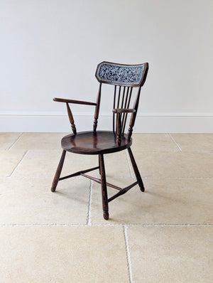 Antique Victorian Arts and Crafts elm and beech Windsor elbow chair with a faceted crest rail, woven panel, and turned splayed legs.