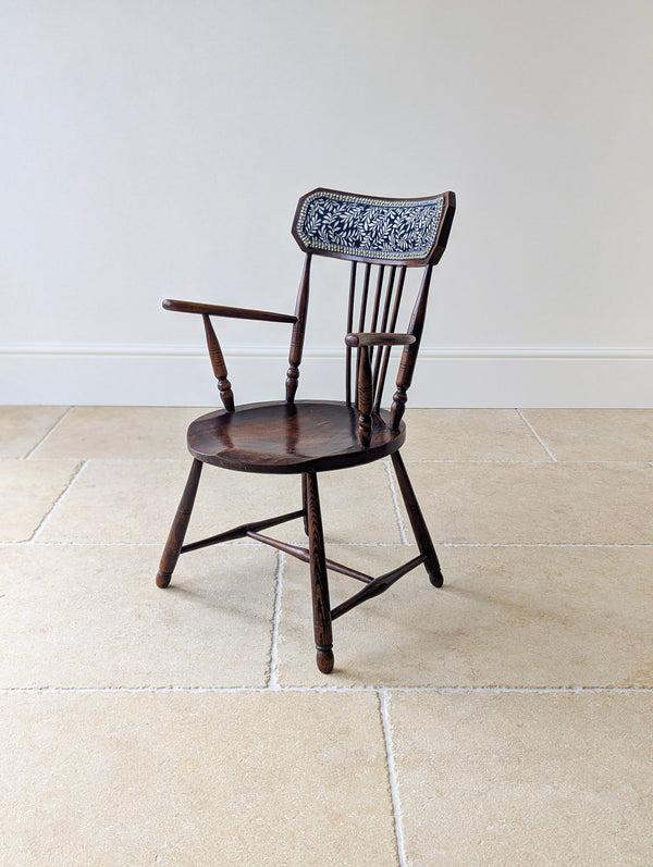 Antique Victorian Arts and Crafts elm and beech Windsor elbow chair with a faceted crest rail, woven panel, and turned splayed legs.
