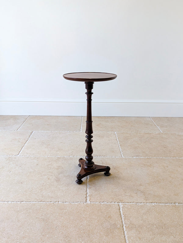 Antique Regency solid mahogany wine table featuring a dished top, turned baluster stem, and concave triform plinth raised on compressed bun feet.