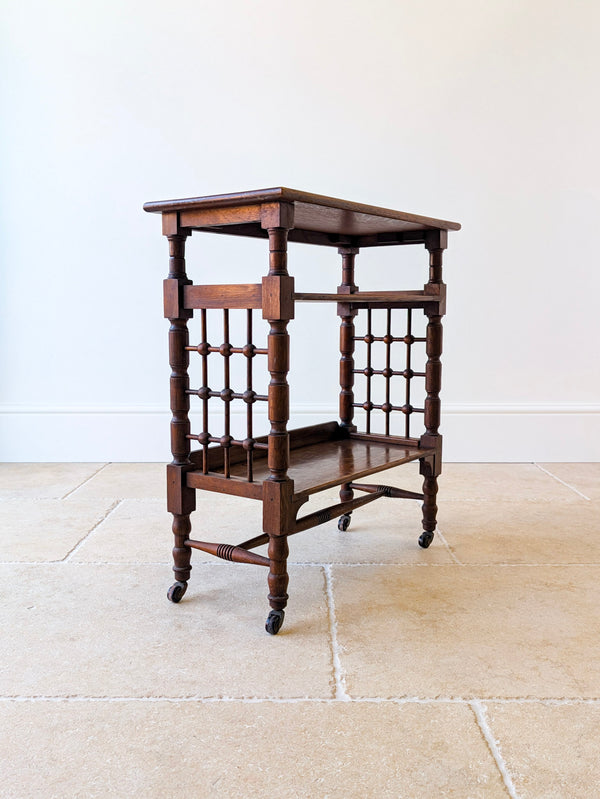 Antique Arts & Crafts oak reading table bookstand featuring turned mashrabiya moorish spindle-lattice side panels, raised on turned legs with brass and ceramic wheel castors.