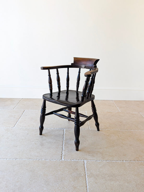 Antique Victorian elm and ash Captain's desk chair with tablet crest rail, arm bow, turned spindles, dished seat, and turned legs with H-stretcher.
