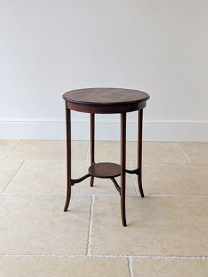 Antique Edwardian mahogany occasional table in the Sheraton Revival taste featuring a circular top over slender legs with shaped stretchers supporting an undertier.