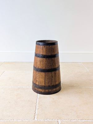 Antique early Victorian coopered oak stick stand of tapered form with dark iron hoops and an integrated base.