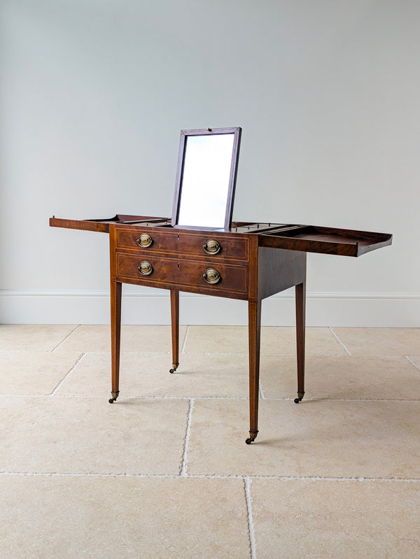 Antique George III mahogany gentleman's folding dressing table with hinged top leaves, fitted cosmetic interior, and square-tapered legs on brass cup castors.