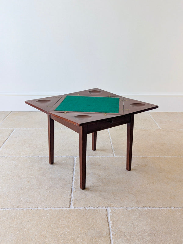 Antique Edwardian mahogany diminutive envelope card table with a swivelling top, green baize surface and a frieze drawer on four square legs.