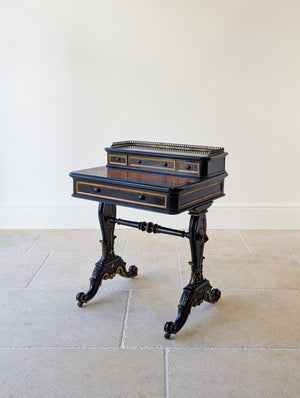 Antique ebonized wood bonheur du jour featuring gilt highlights and a pierced brass gallery and four drawers on scrolled feet.