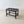 Load image into Gallery viewer, Antique Edwardian oak luggage stand featuring five flush-fitted slats over four square-section legs united by a low perimeter box stretcher.
