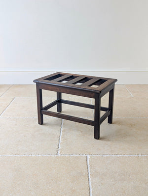 Antique Edwardian oak luggage stand featuring five flush-fitted slats over four square-section legs united by a low perimeter box stretcher.