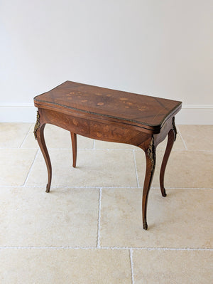Antique late Victorian Louis XV style kingwood card table featuring floral marquetry, ormolu mounts, a serpentine frieze, and cabriole legs.