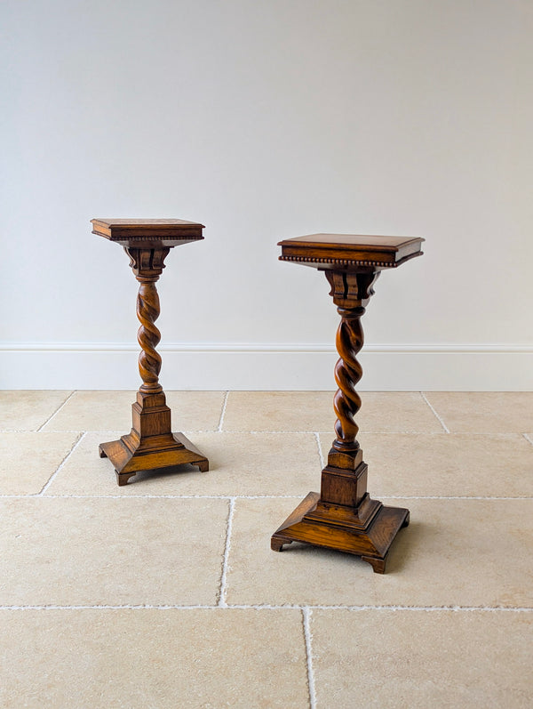 Antique Late Victorian golden oak pair of torchères featuring figured square tops, solid barley twist columns and stepped plinth bases.