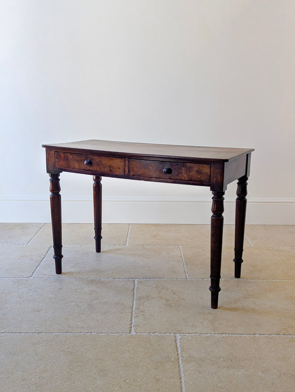 Antique Early Victorian mahogany writing table with a pair of frieze drawers, raised on ring-turned tapered baluster legs.