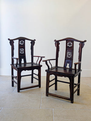 Antique Late Qing Dynasty hardwood pair of yoke-back armchairs with carved back splats and serpentine arms on square-section legs with stepped stretchers.
