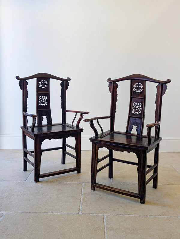 Antique Late Qing Dynasty hardwood pair of yoke-back armchairs with carved back splats and serpentine arms on square-section legs with stepped stretchers.
