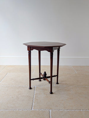 Antique Late Victorian Aesthetic Movement mahogany octagonal occasional table with a flame-figured top on ring-turned tapered legs united by an X-stretcher with turned finial.