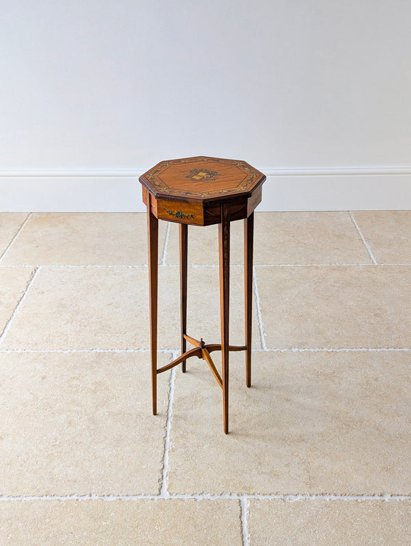 Antique Edwardian painted satinwood candle stand featuring an octagonal top decorated with a musical trophy medallion, raised on square-tapered legs with an X-form stretcher.