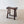 Load image into Gallery viewer, Antique Georgian vernacular oak low stool featuring a carved single-slab saddle seat over four splayed legs with staggered pegged stretchers.
