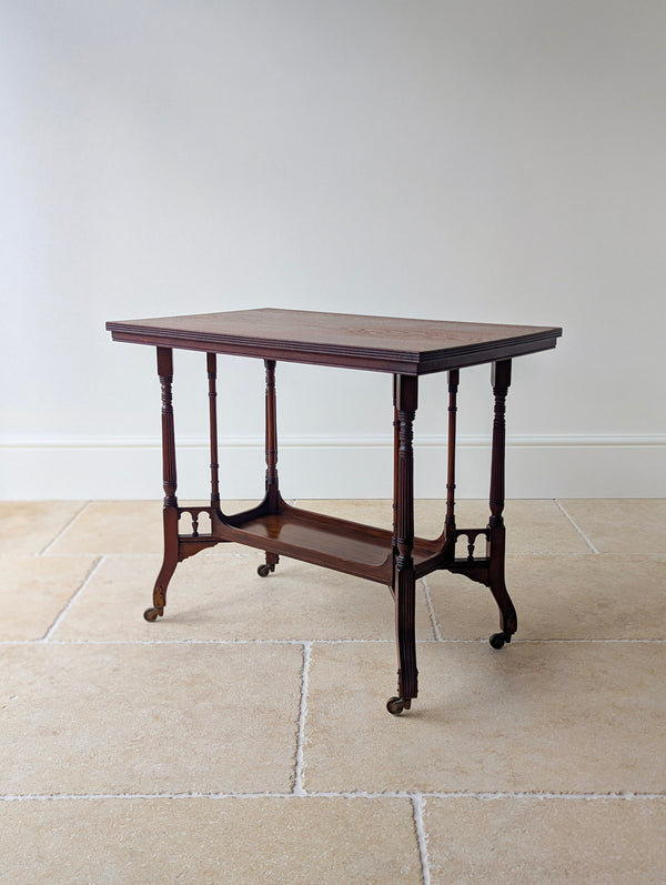 Antique late Victorian mahogany centre table by Gregory & Co featuring a rectangular top, lower tier, and out-swept reeded legs with stirrup castors.