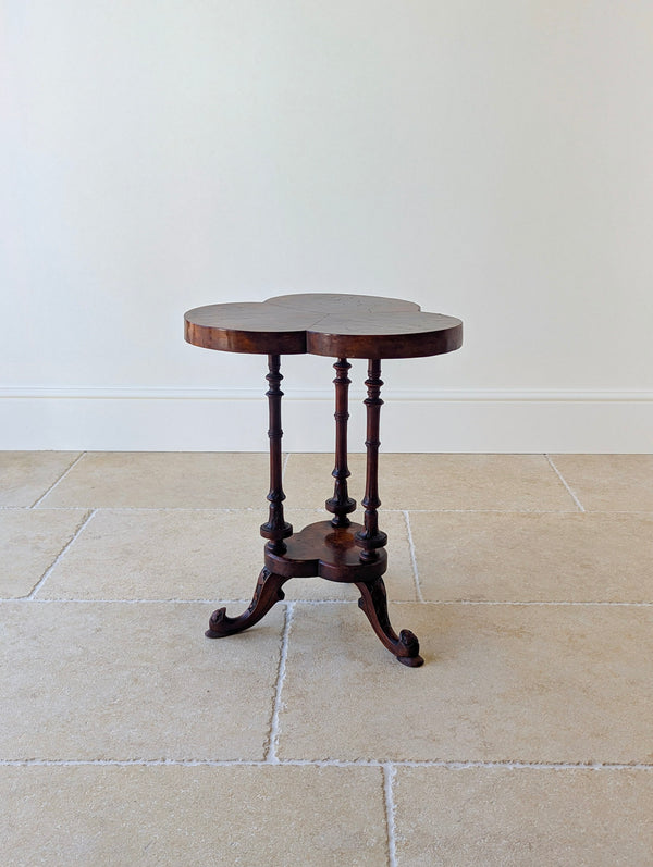 Antique Victorian burr walnut trefoil occasional table with a radially segment-cut top, turned solid supports, matching lower tier, and carved tripod legs.