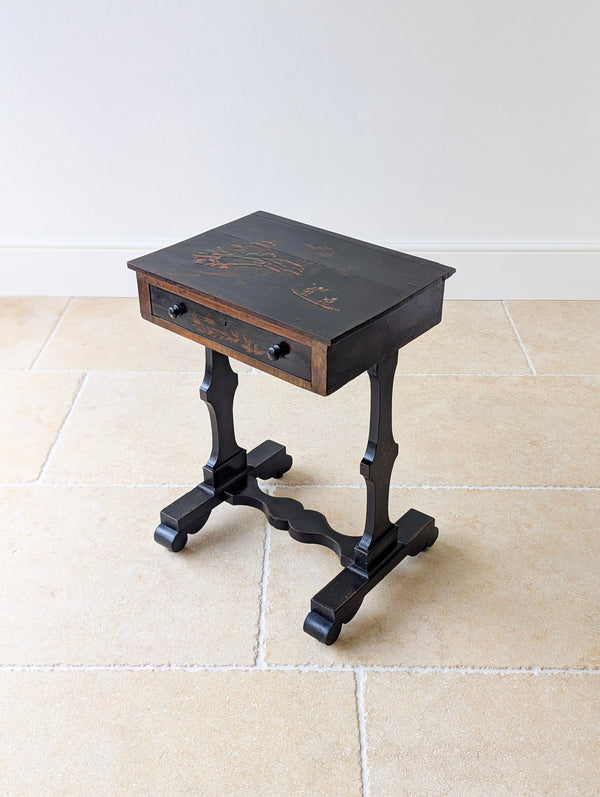 Antique Regency ebonised Chinoiserie work table with a hand-painted japanned top over a frieze drawer raised on flat trestle uprights.