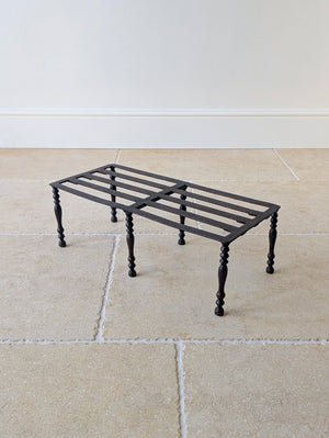 Antique Georgian wrought iron hearth footman with a slatted rectangular top, lapped frame joints, central hand-peened transverse spine, and six baluster legs.